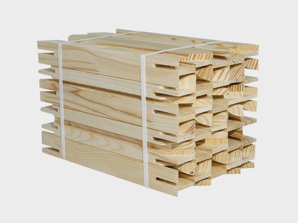 Stacked light wood boards with interlocking joints on a white background