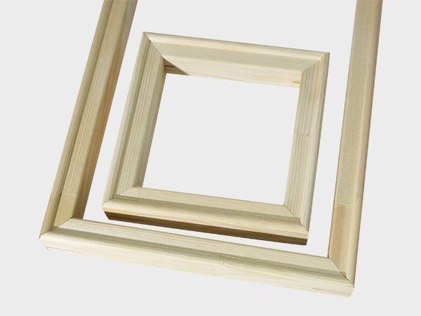 Stacked wooden square frames on a white background, one tilted inside a larger frame