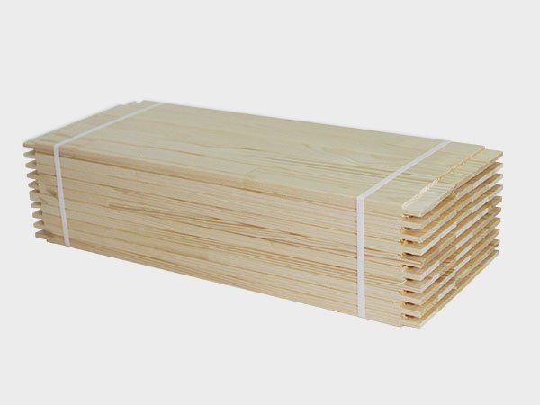 Stack of light-colored wooden boards bundled with white straps on a white background