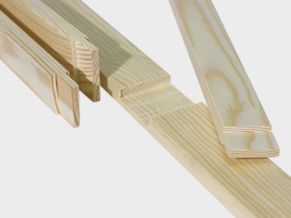 Three light-colored wooden wedges stacked on a white background