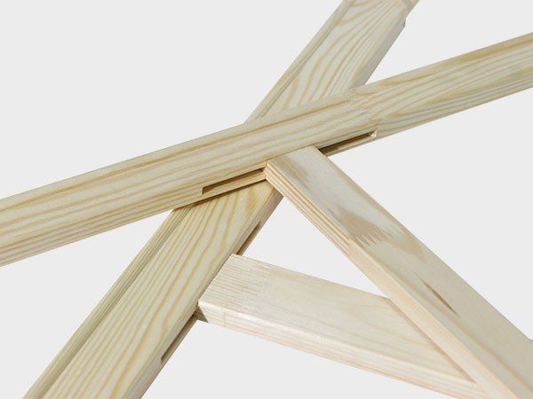 Close-up of several pale wooden sticks crossed together on a white background
