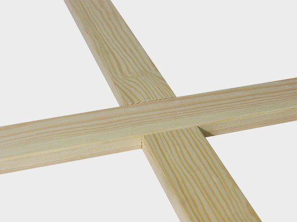 Two light wood strips crossing in an X shape on a white background