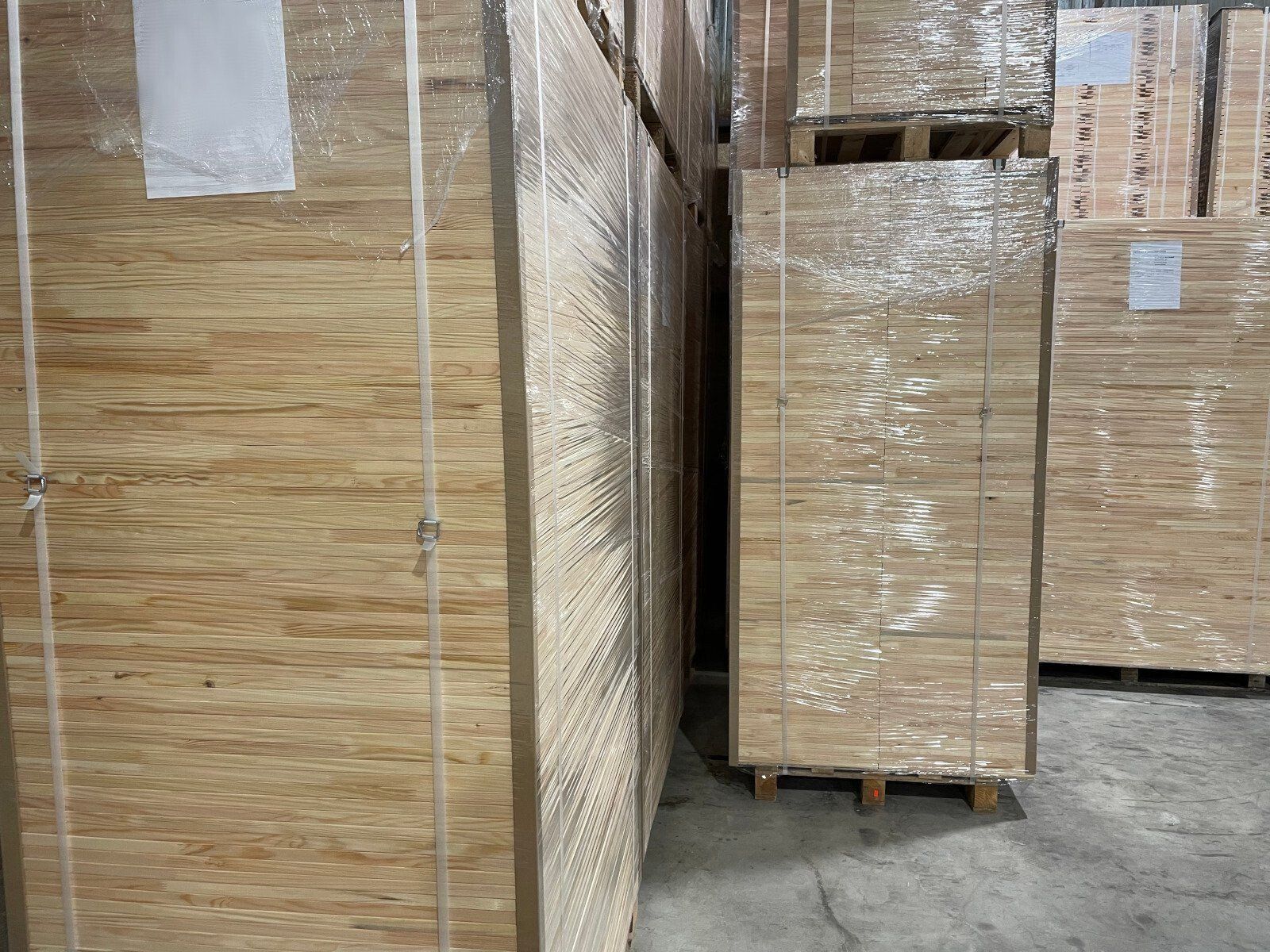 Stacked cardboard boxes wrapped in plastic in a warehouse aisle