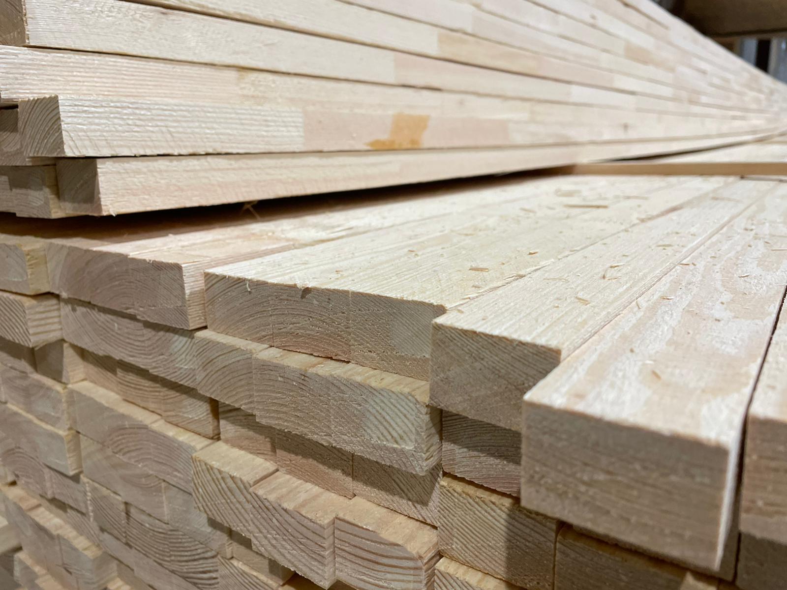 Stacked pale wooden planks in a lumber yard