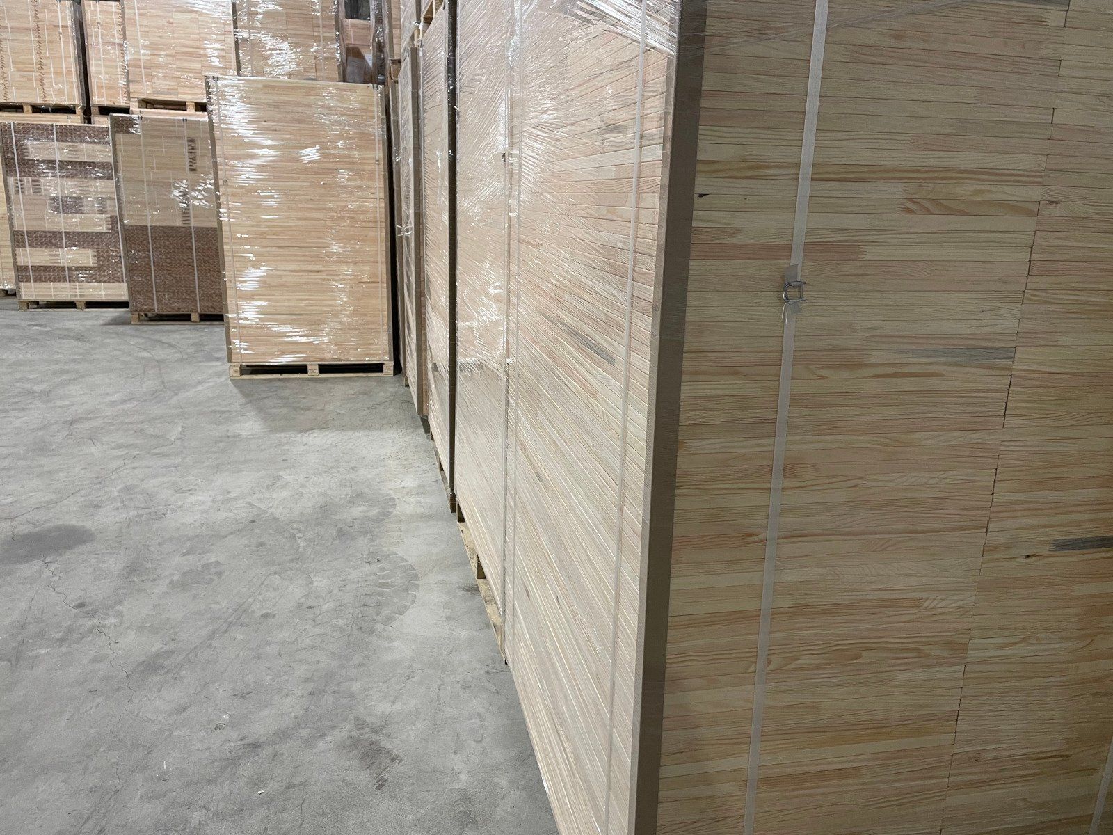 Stacked wooden crates wrapped in plastic in a warehouse aisle