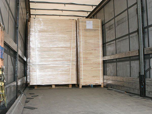 Truck trailer loaded with large wrapped pallets of crates inside the cargo bay
