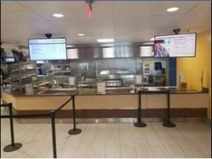 Cafeteria food service area with menu boards and serving counters.