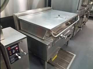 Commercial stainless steel tilting braising pan in a kitchen.