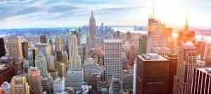 Aerial view of the New York City skyline with the Empire State Building prominent, bathed in sunset light.