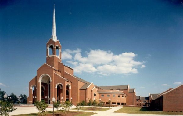 Brick church building with steeple against a blue sky.