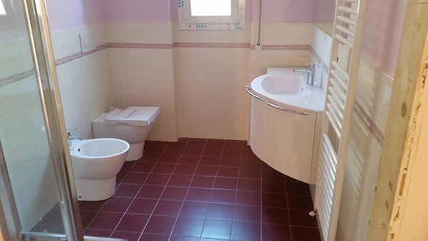 Bagno con pavimento granata.