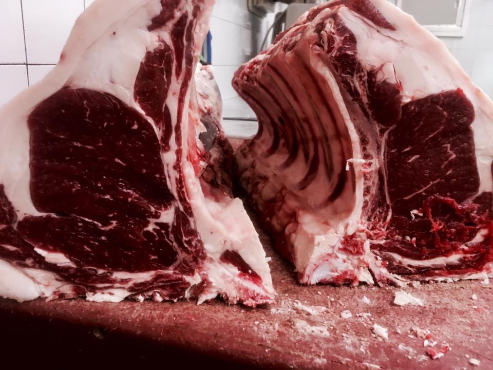 Due grandi tagli di carne rossa cruda, aperti per mostrare l'osso.