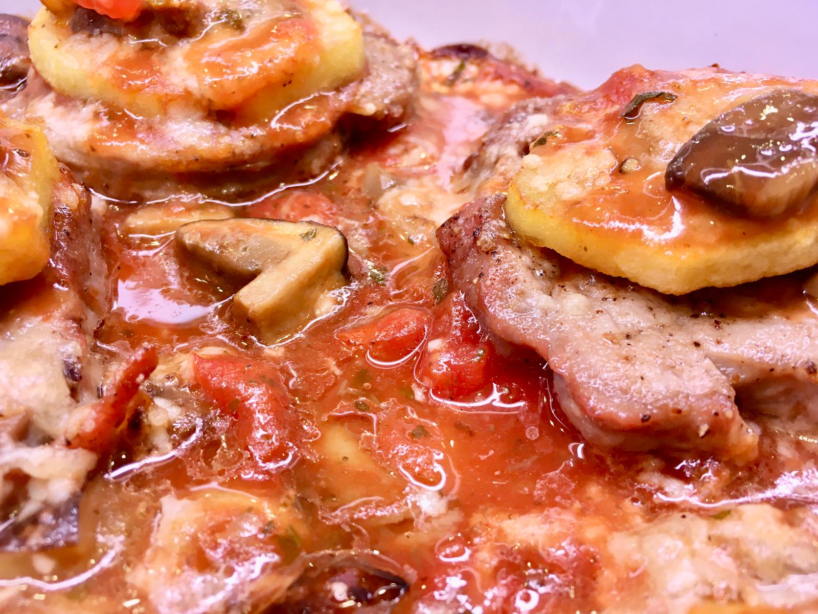 Primo piano di pollo con salsa di pomodoro, funghi e zucchine.