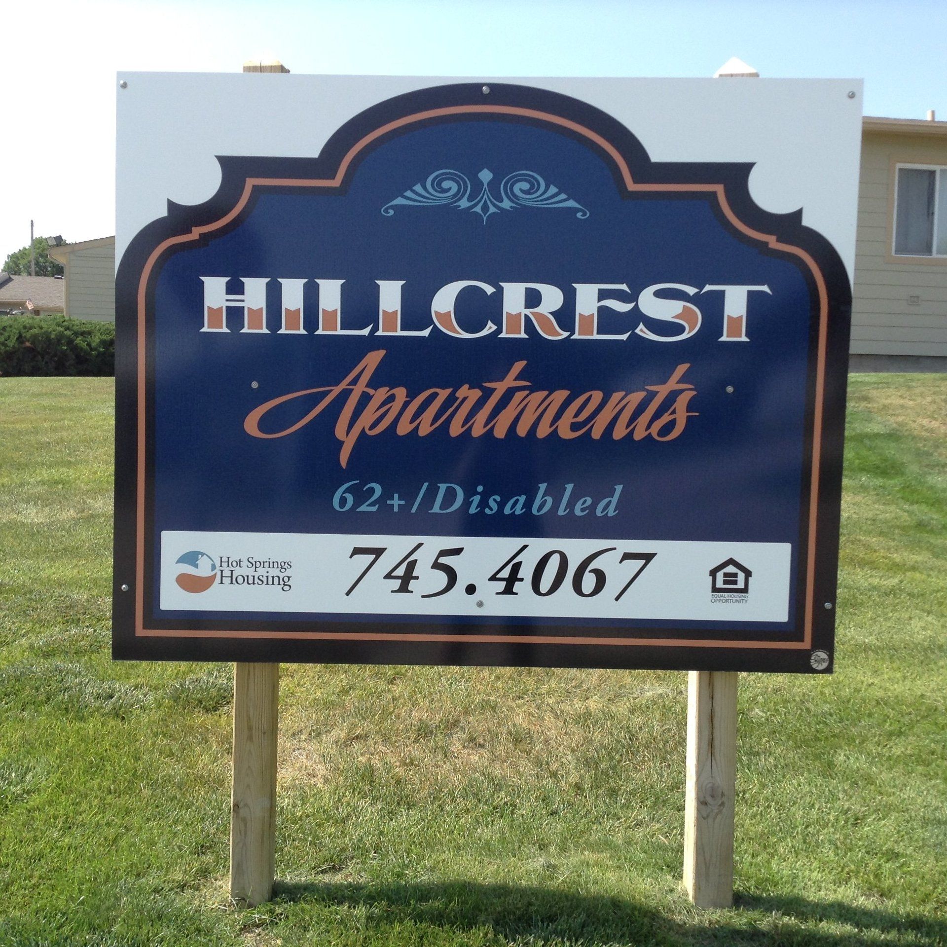 Sign for Hillcrest Apartments, 62+/Disabled, blue and orange lettering.