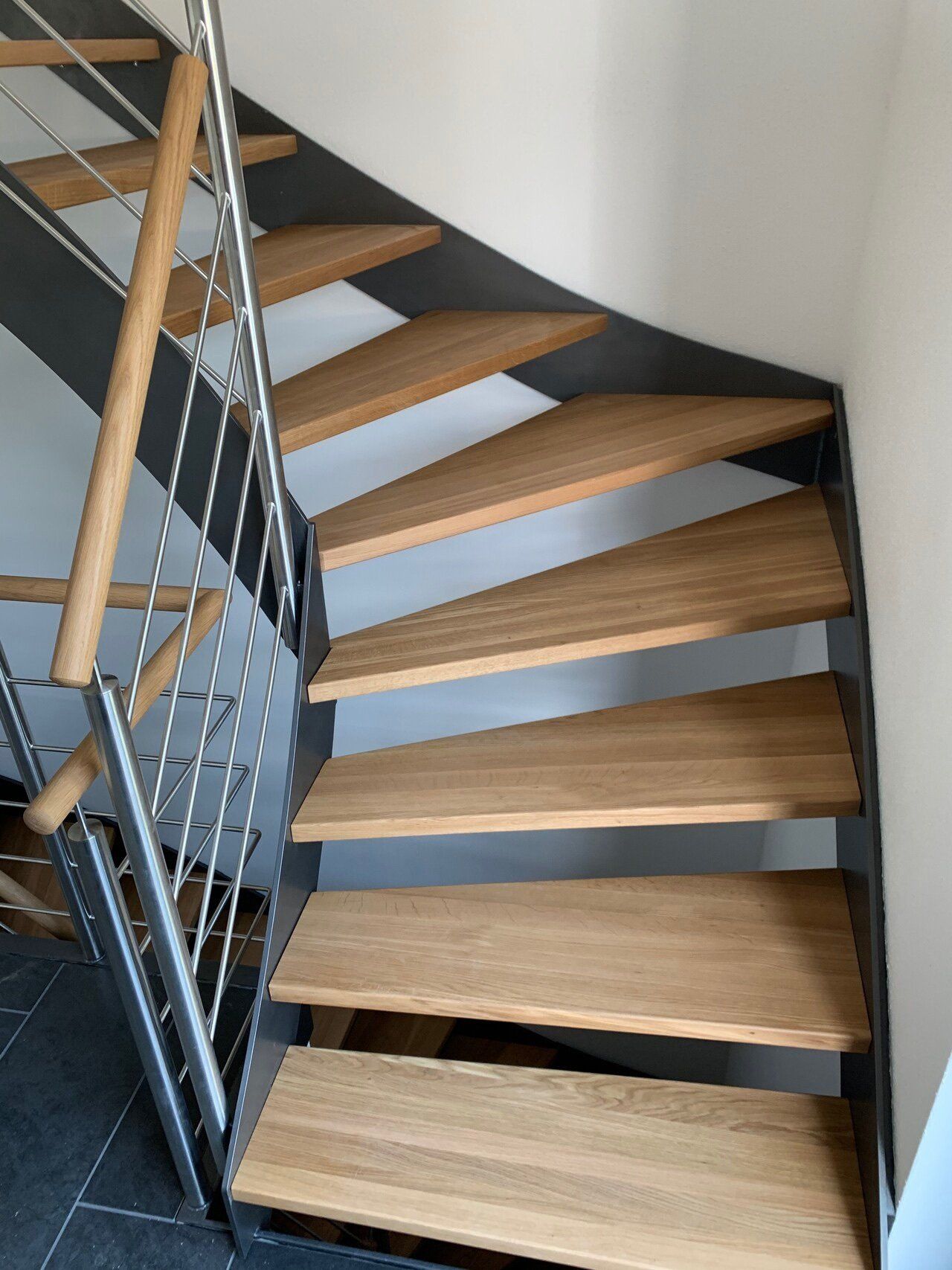 Eine Wendeltreppe mit Holzstufen und einem Metallgeländer.