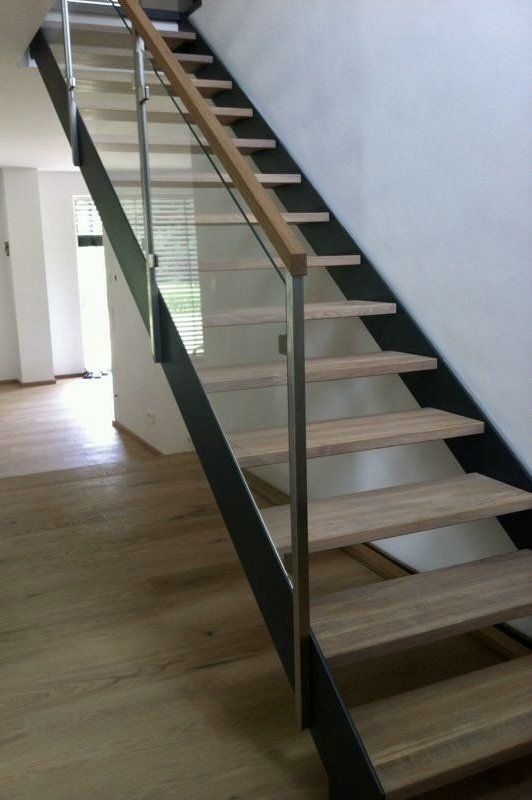 Eine Treppe mit Holzstufen und einem Glasgeländer