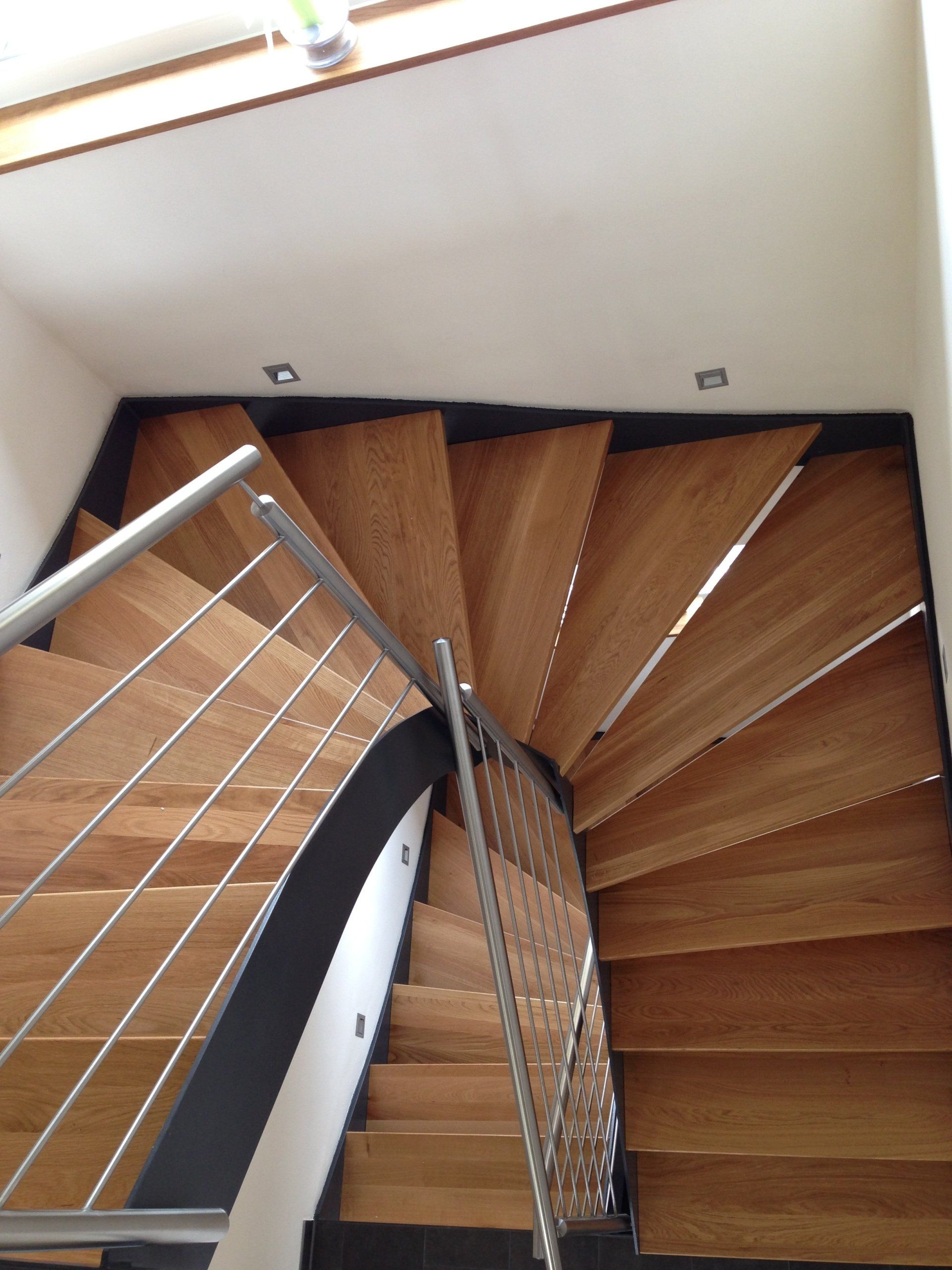 Eine hölzerne Wendeltreppe mit einem Metallgeländer