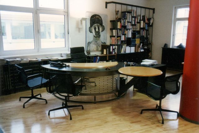 Ein Raum mit einem Tisch und Stühlen und einem Gemälde an der Wand