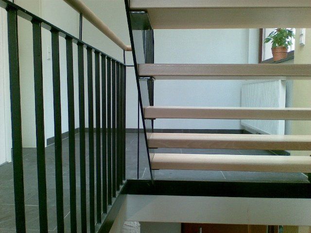 Eine Treppe mit schwarzem Geländer und Holzstufen