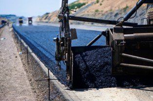 Industrial pavement truck laying fresh asphalt — Paving Contractors In Butler, PA Industrial pavement truck laying fresh asphalt — Paving Contractors In Butler, PA