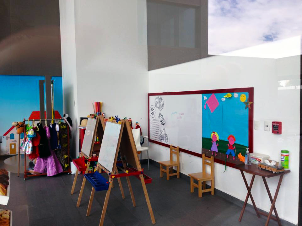 Una habitación infantil con pizarra blanca y caballetes.