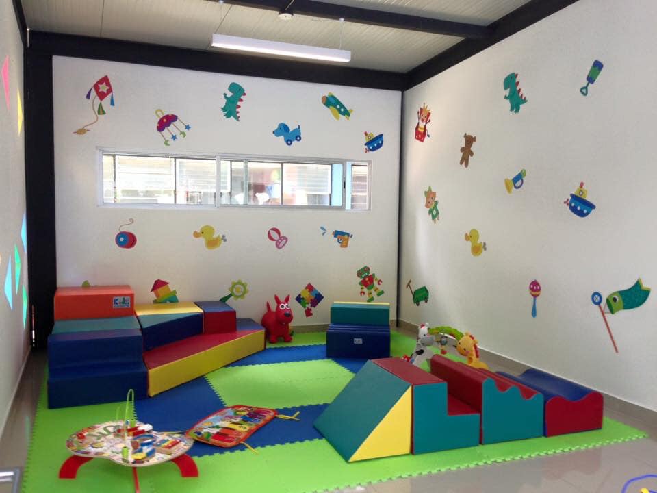 Una habitación con muchos juguetes y pegatinas en la pared.