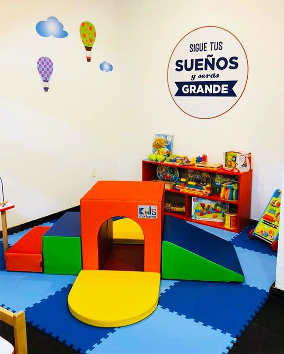 Una colorida área de juegos con un letrero que dice sigue tus sueños grandes