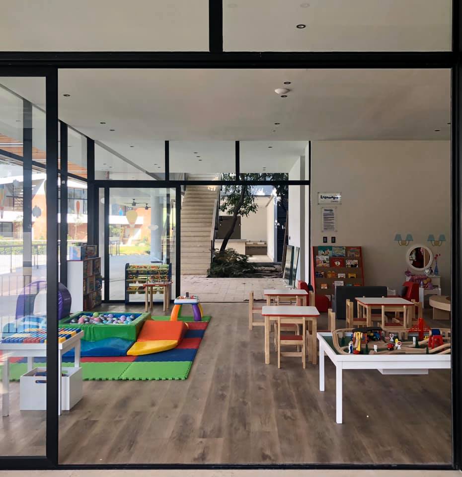 Una gran sala con mesas y sillas y un tobogán