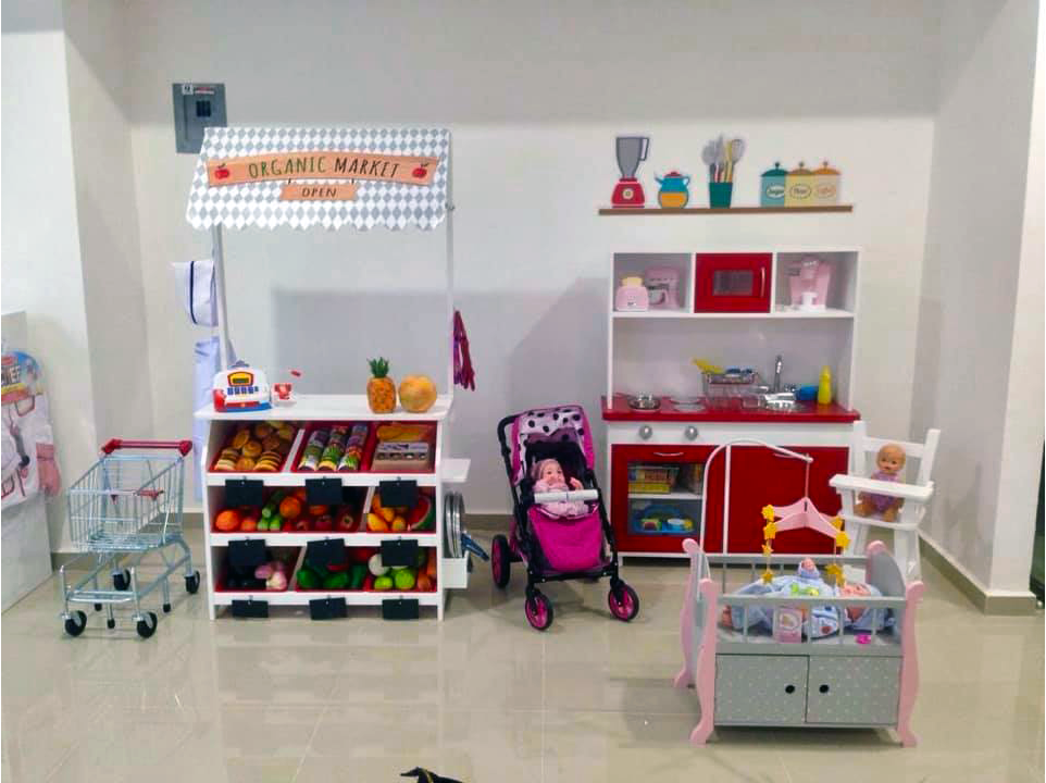 Una habitación con un bebé en un cochecito y una cocina.