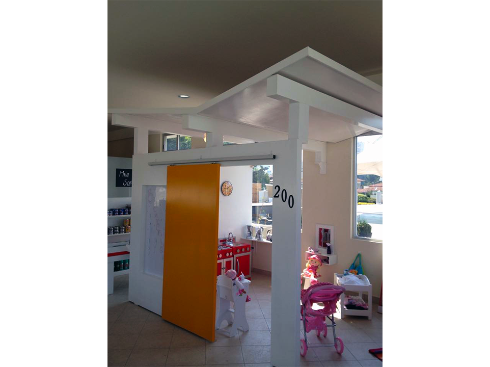 Una habitación con una puerta corredera que parece una casita de juegos.