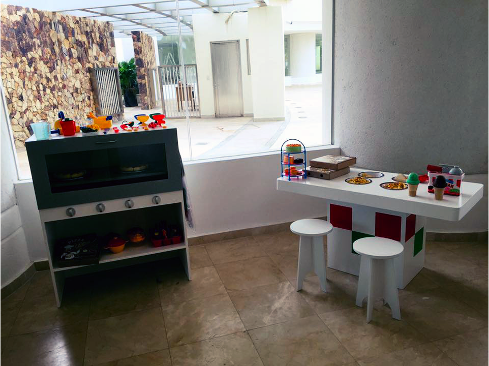 Una habitación con una mesa, taburetes y juguetes encima