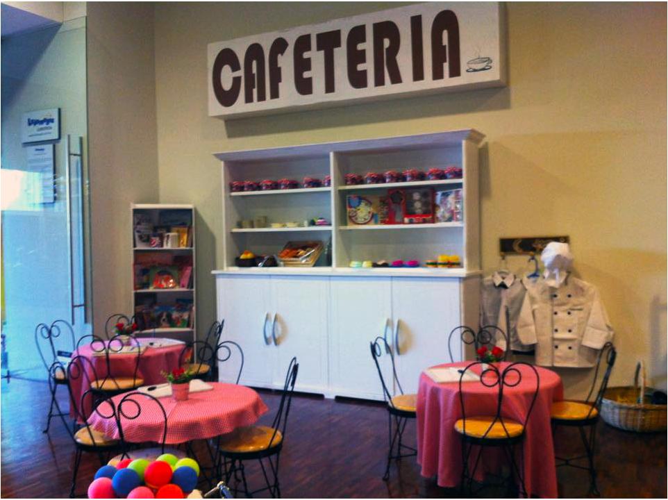 Una cafeteria con mesas y sillas y un cartel que dice cafeteria