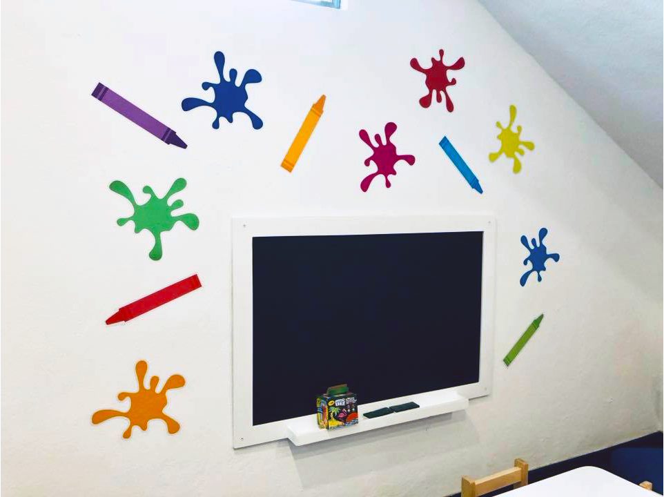 Una pared con un televisor de pantalla plana y pegatinas de colores