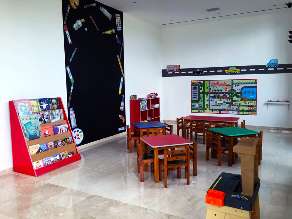 Un salón de clases con mesas y sillas y una pizarra en la pared