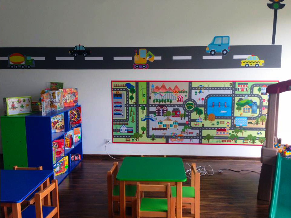 Una habitación infantil con mesas y sillas y un mapa en la pared.