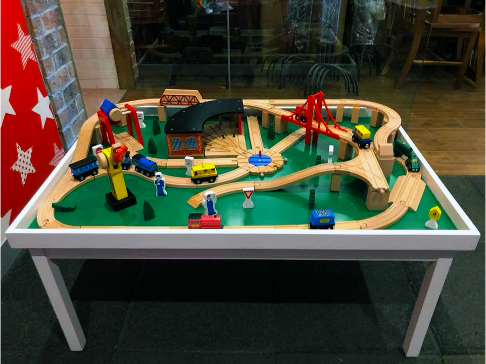Una mesa con un tren de madera encima