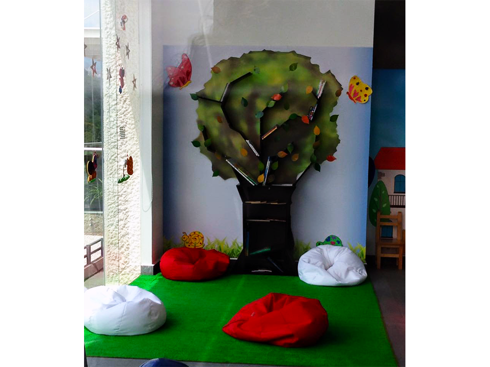 Una habitación con sillones tipo puf y un árbol en la pared.
