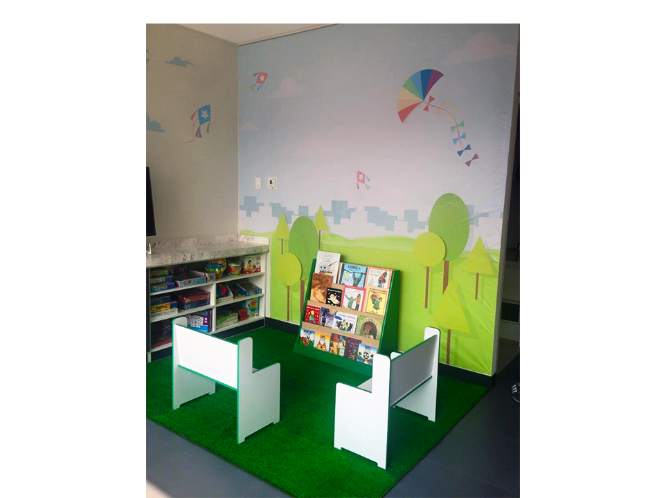 Una habitación infantil con mesa, sillas y estantería.