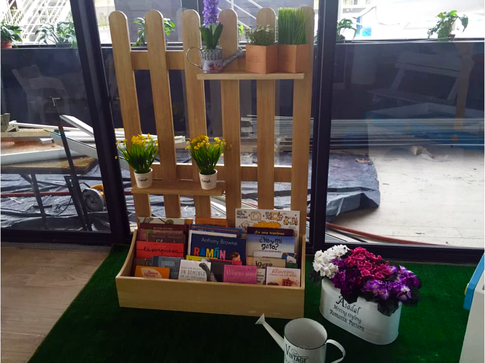 Una valla de madera con libros y flores
