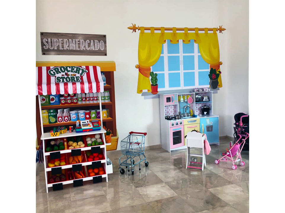 Una habitación con una tienda de juguetes y una cocina de juguete.