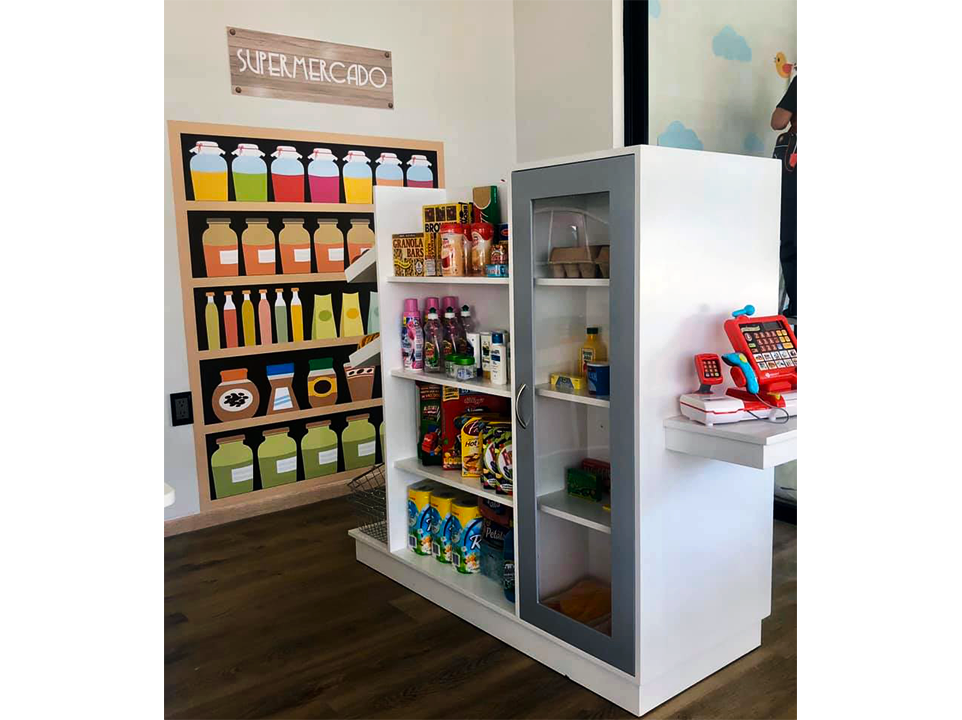 Una tienda de juguetes con refrigerador y estantes llenos de comida.