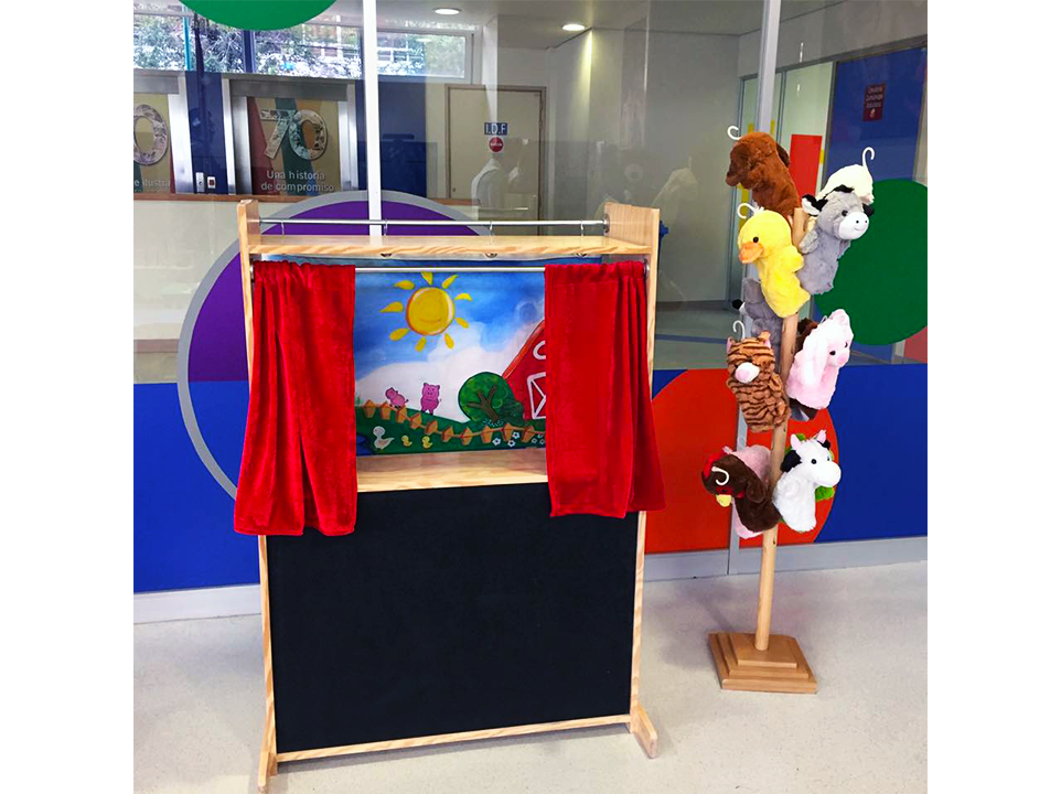 Un teatro de marionetas con un montón de animales de peluche en un stand