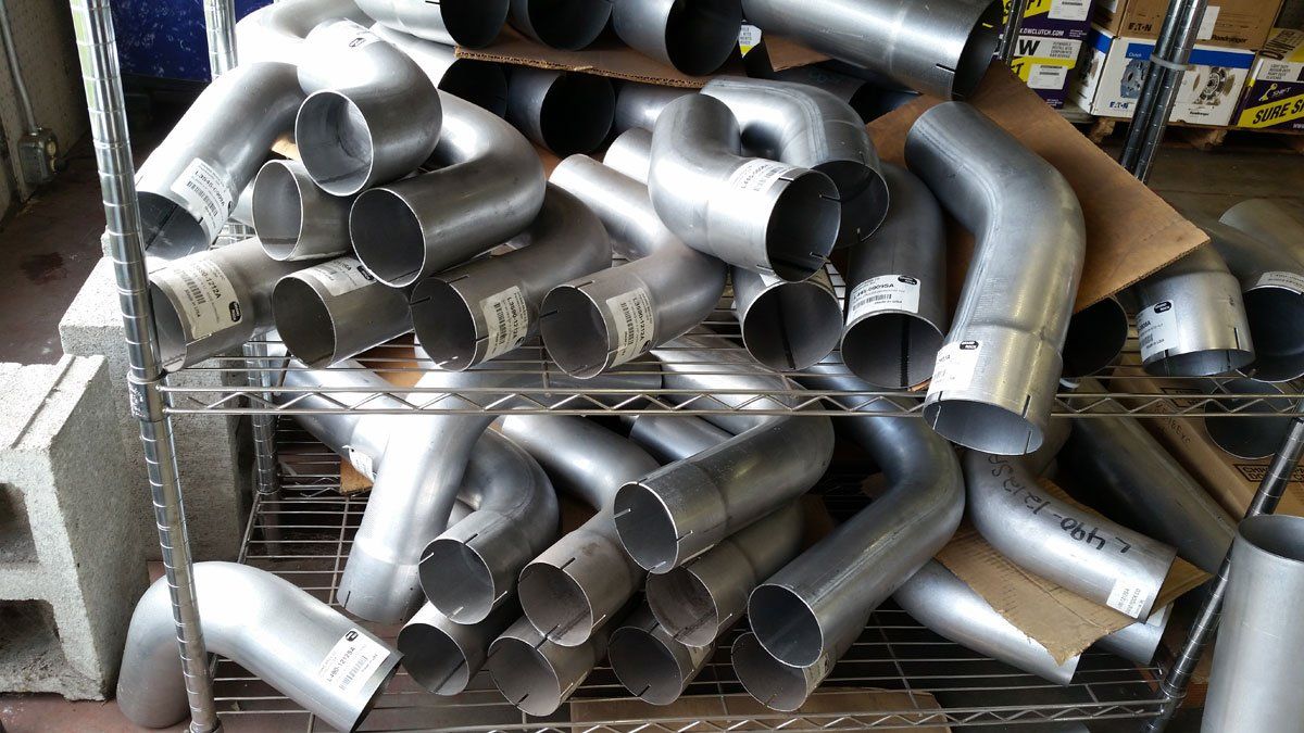 A collection of steel exhaust pipes piled on top of each other