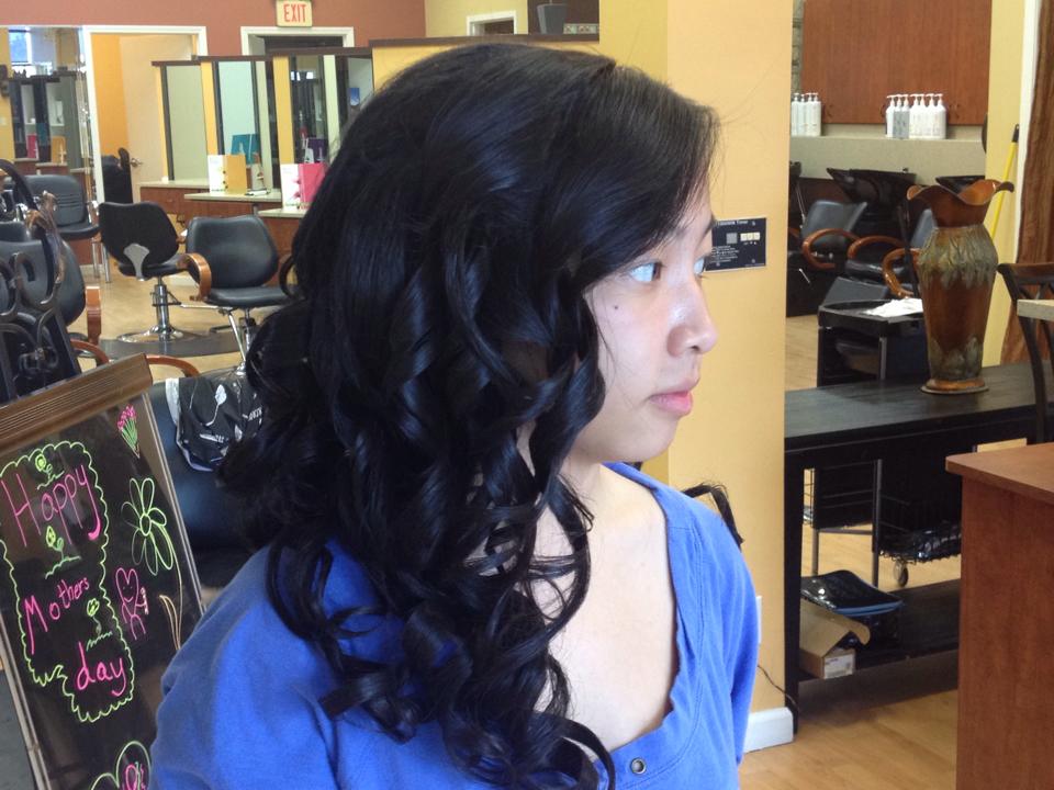 A woman in a blue shirt is in a hair salon