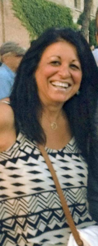 A woman with long black hair is smiling for the camera.