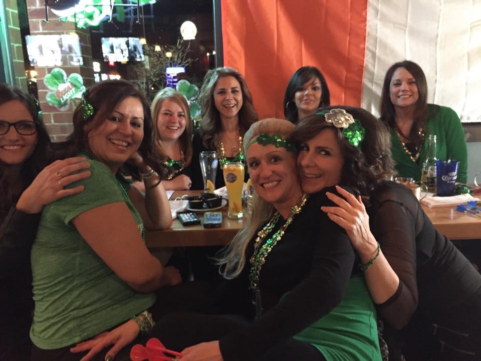 A group of women are posing for a picture at a table