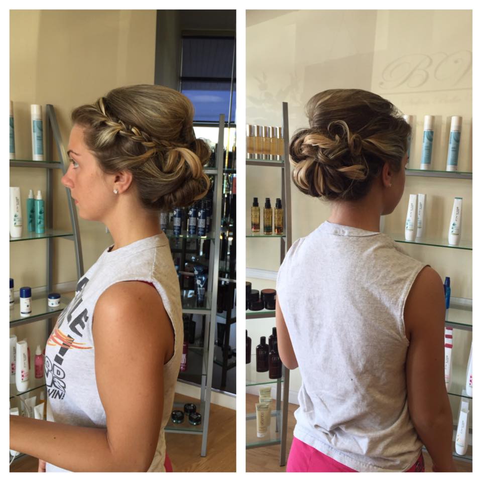 A woman is wearing a braided bun in a salon
