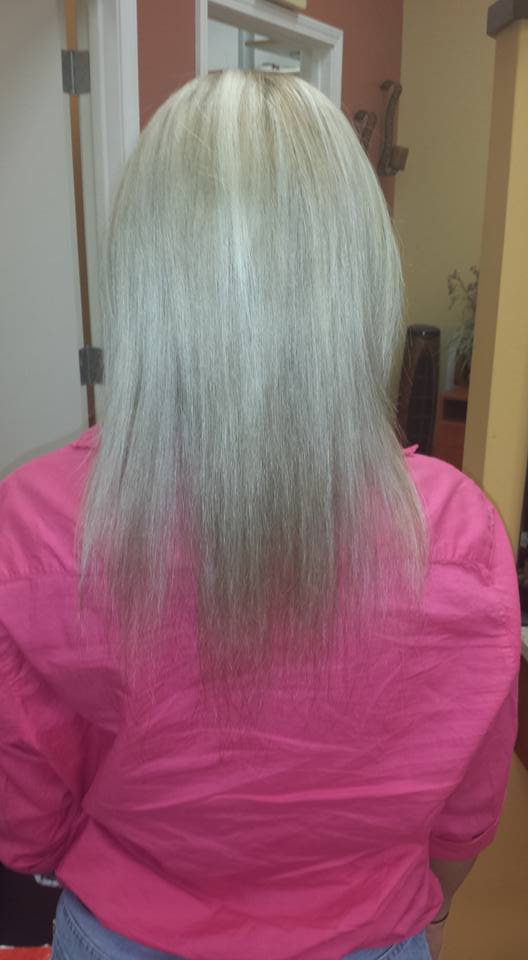 The back of a woman 's head with gray hair and a pink shirt.