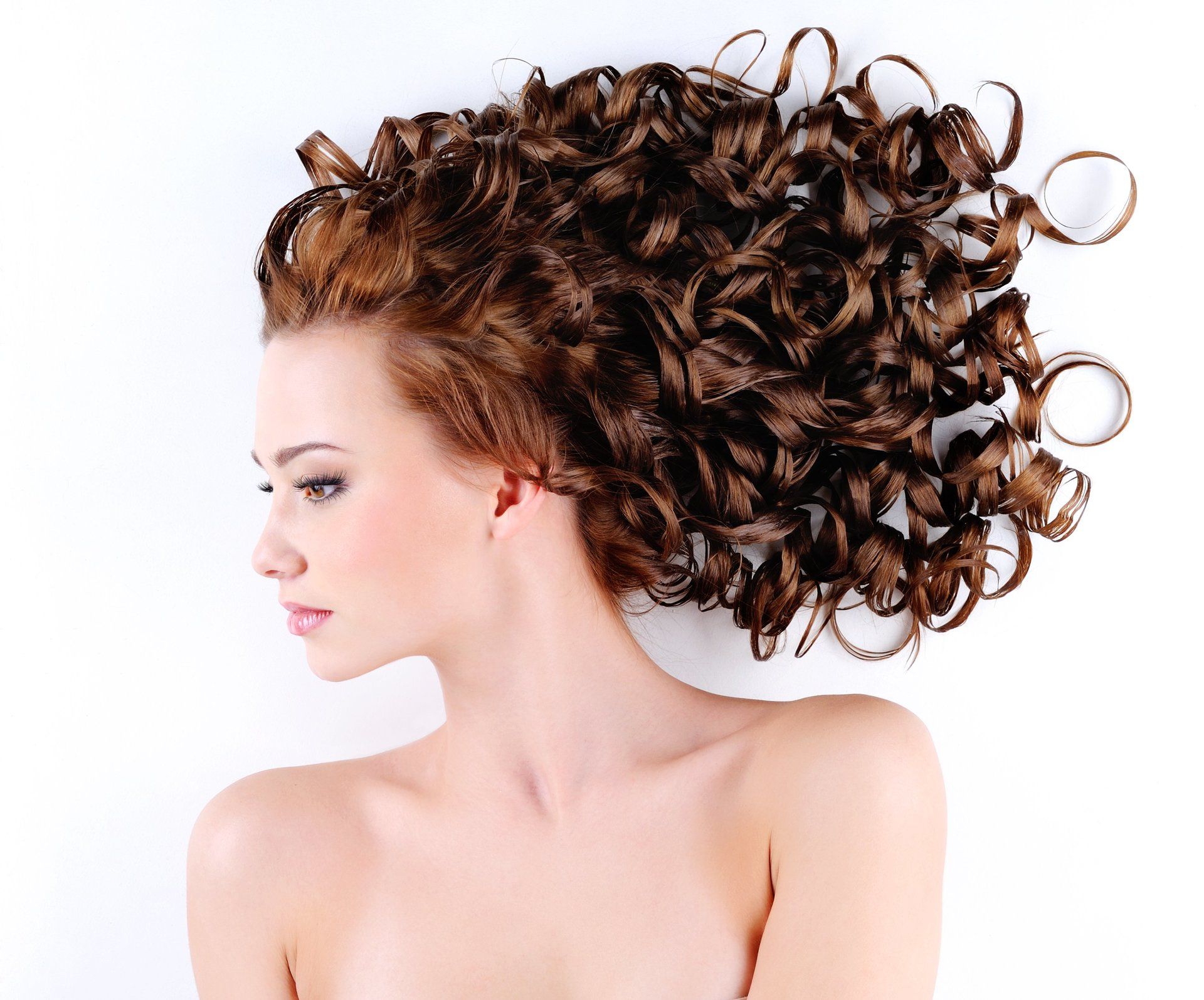 A woman with curly hair is laying on her back