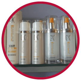 Several bottles of ck hair products are lined up on a shelf